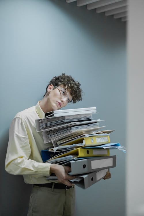 Free Person in Yellow Long Sleeve Shirt Carrying Stack of Office Files Stock Photo Free Person in Yellow Long Sleeve Shirt Carrying Stack of Office Files Stock Photo