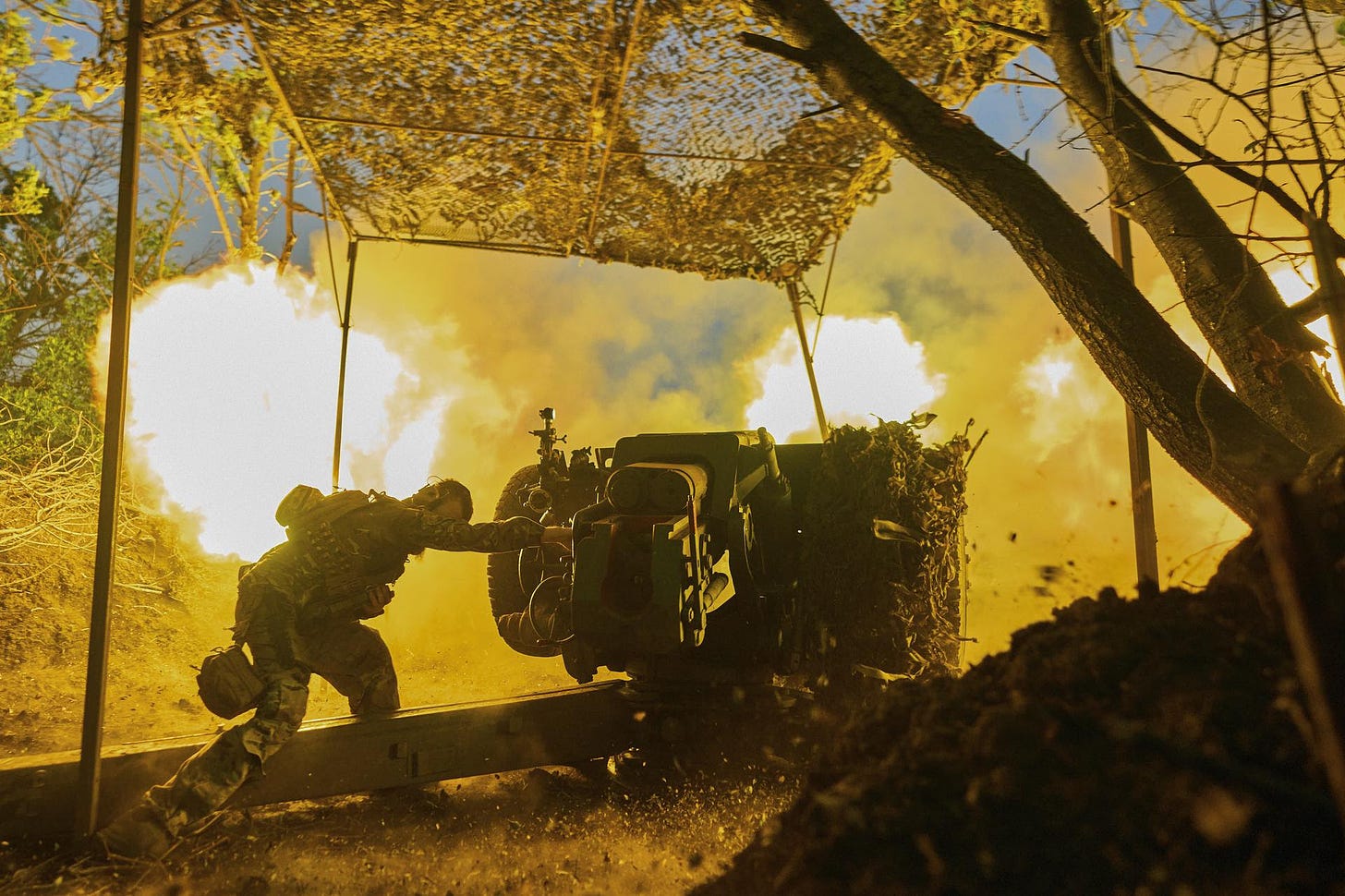 A Ukrainian serviceman fires a D-30 cannon toward Russian positions
