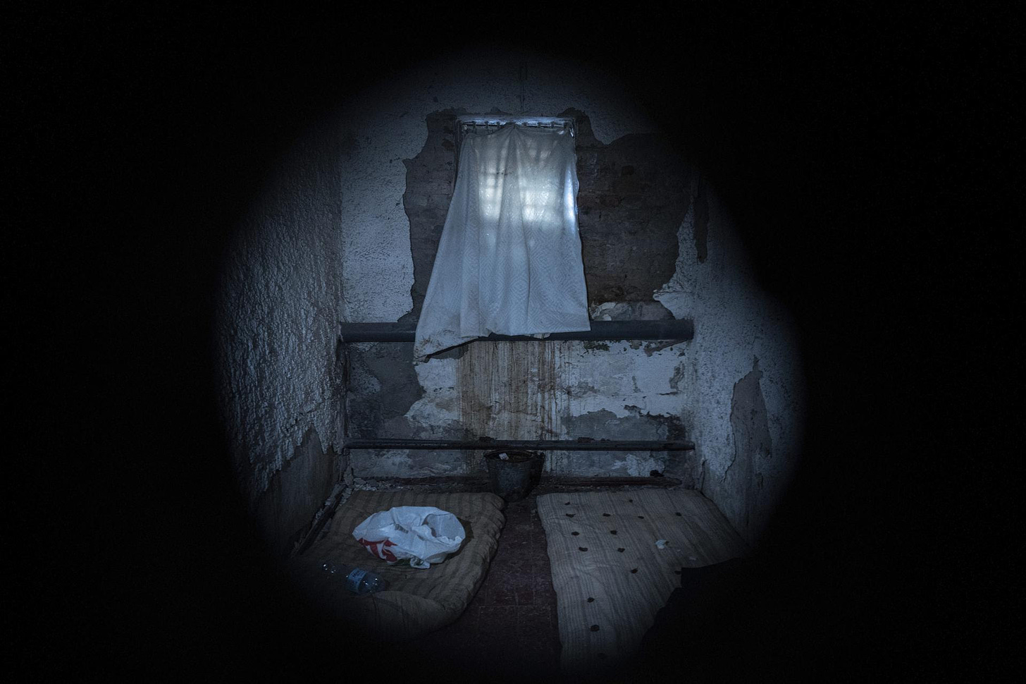 Seen through a peephole, a jail cell in Izium, Ukraine