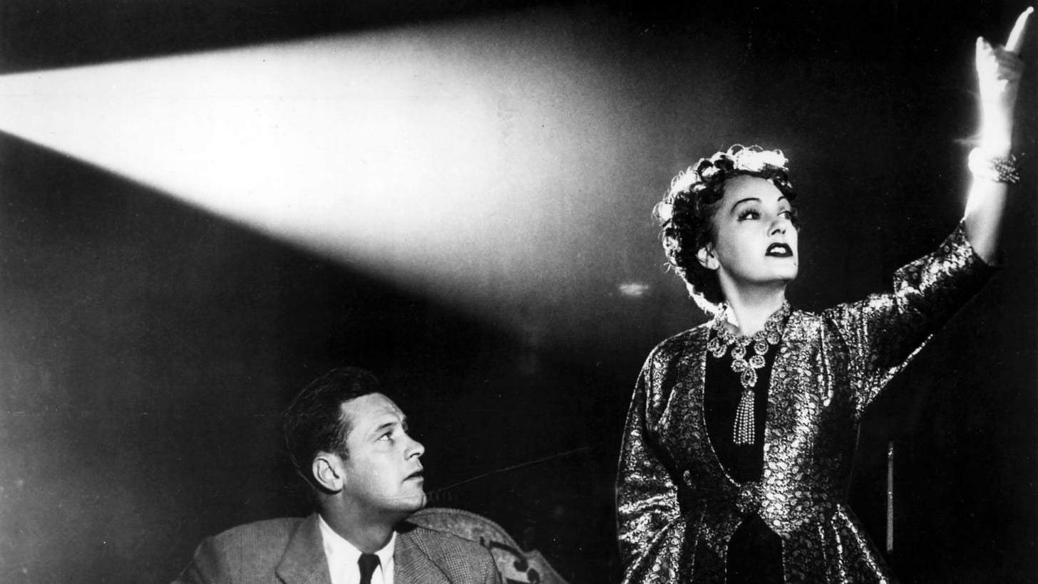 William Holden watches Gloria Swanson gesticulate under a beam of light in "Sunset Boulevard" (1950)