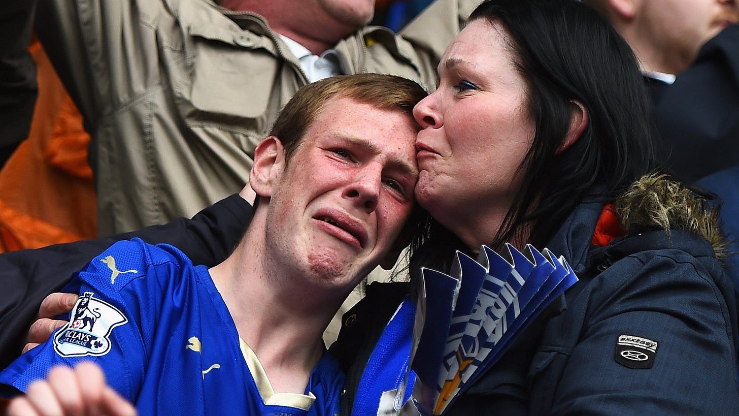 Leicester City fans cry in the stadium after their team is relegated.