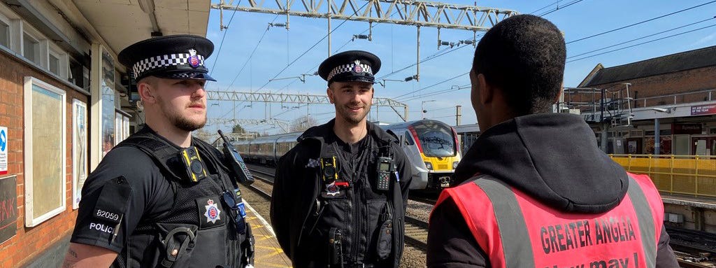 Essex police officers talking to Greater Anglia staff at Colchester train station