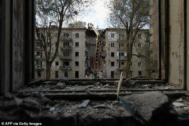 Rescuers clear the rubble of a destroyed residential building following a missile attack in Lugansk, Russian-controlled Ukraine, on June 7