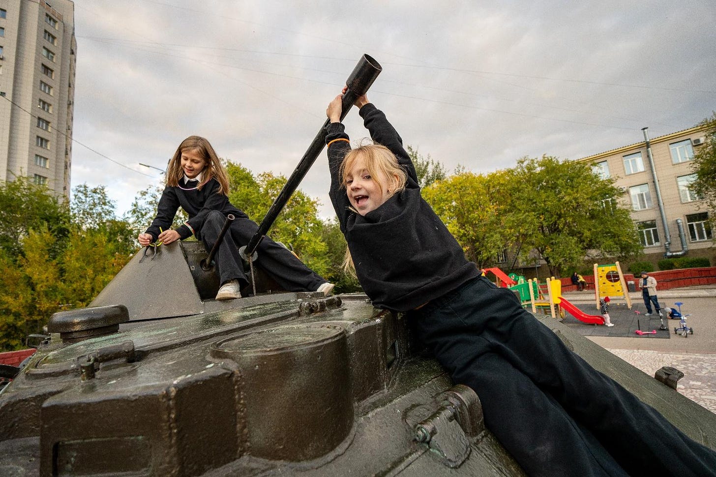 Two girls in black clothes holding a hammer on a tank

Description automatically generated with medium confidence