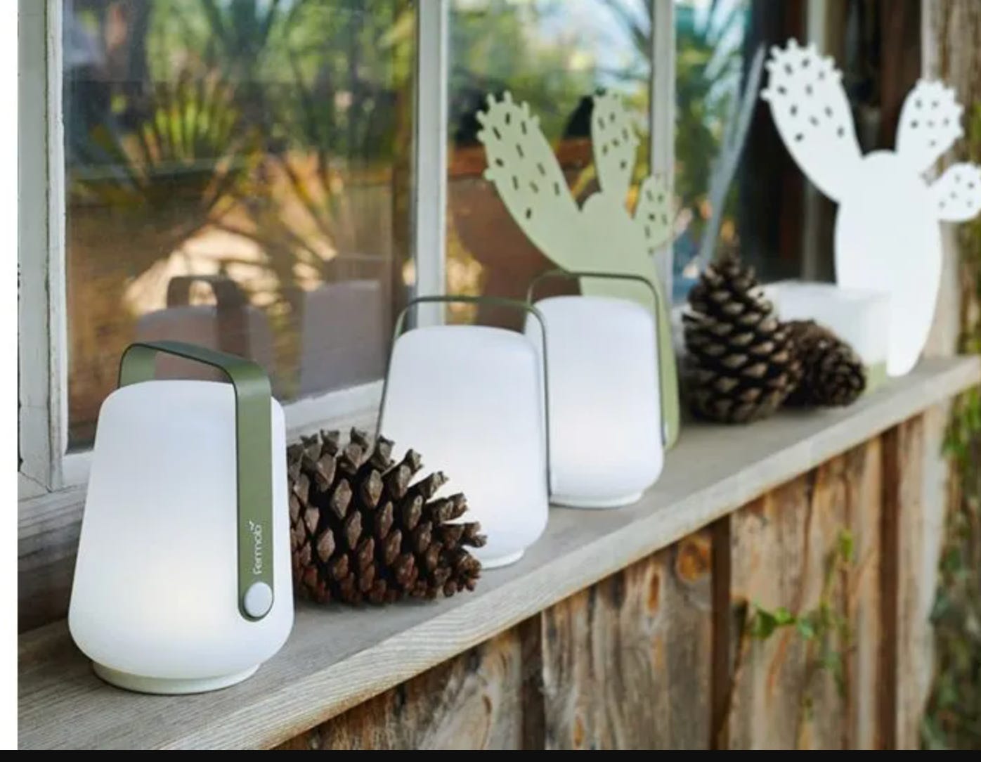 trio of outdoor lamps sitting on a window sill