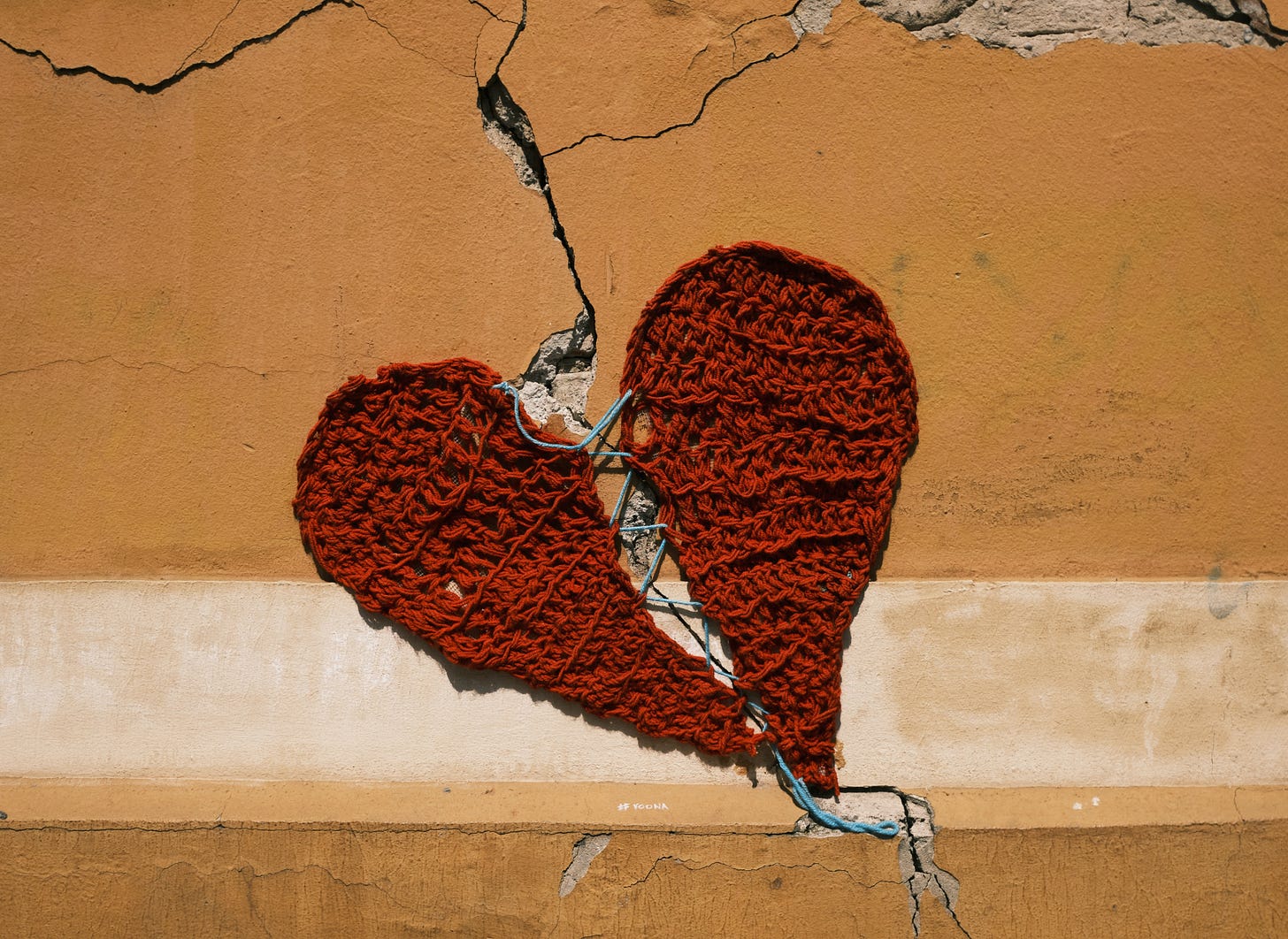 Cracked wall with a fabric heart that needs repair