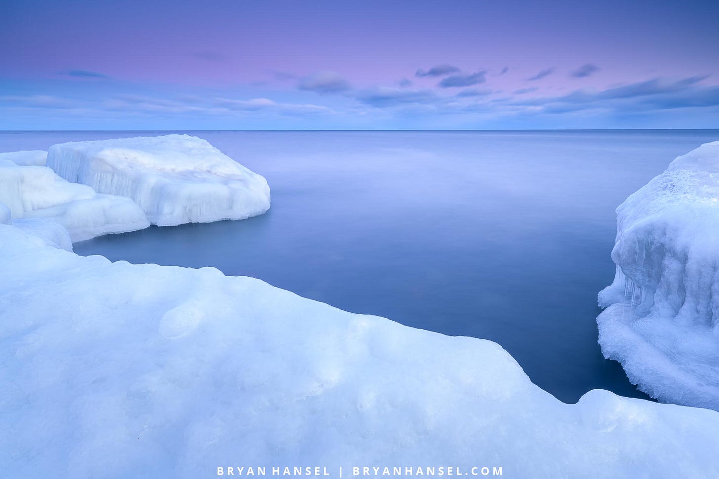 A photo of an icy shoreline under blue and pink skies.