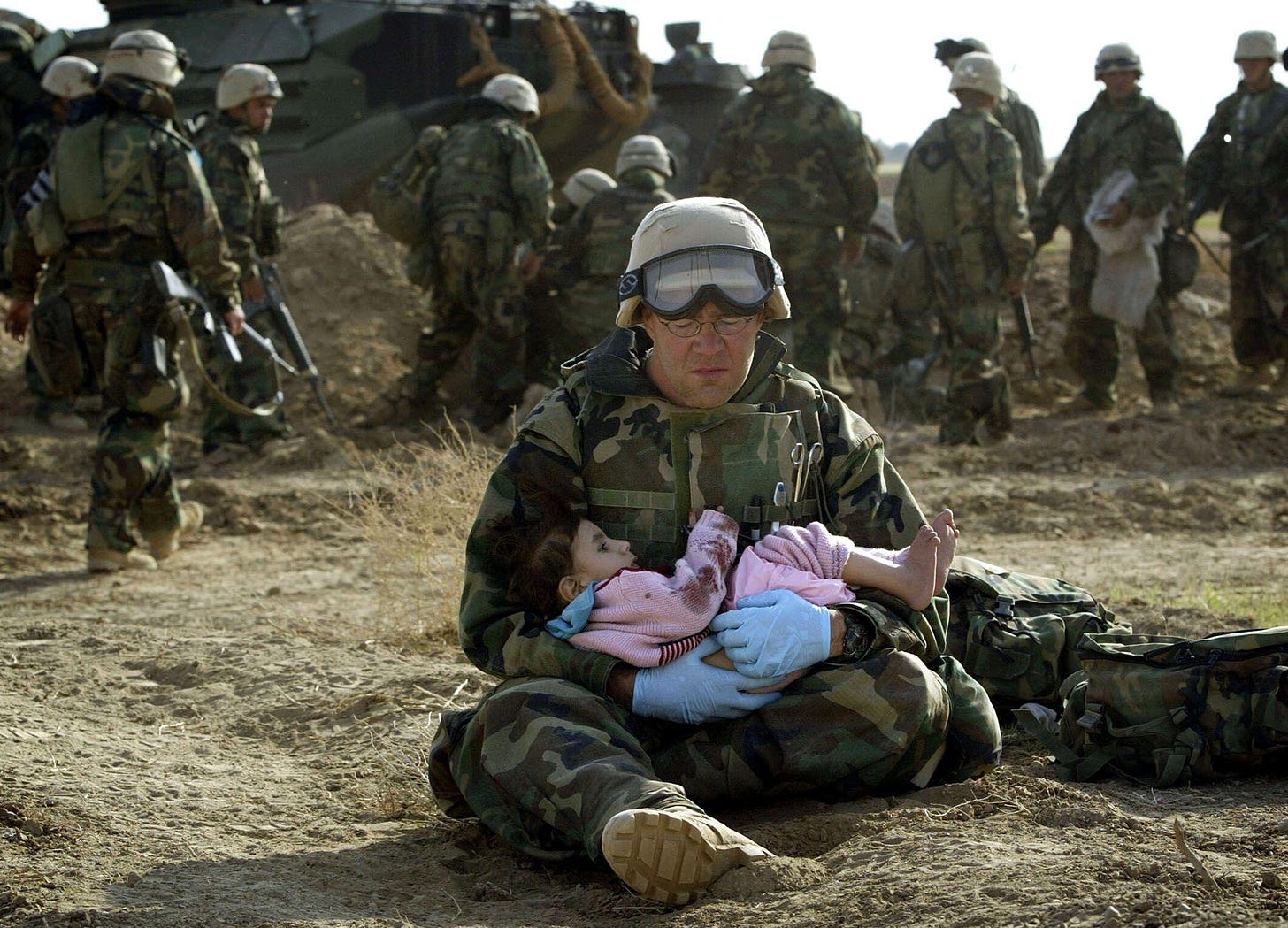 2D3XN9W A U.S. marine doctor holds an Iraqi girl in central Iraq March 29, 2003. Confused front line crossfire ripped apart an Iraqi family on Saturday after local soldiers appeared to force civilians towards U.S. marines positions.