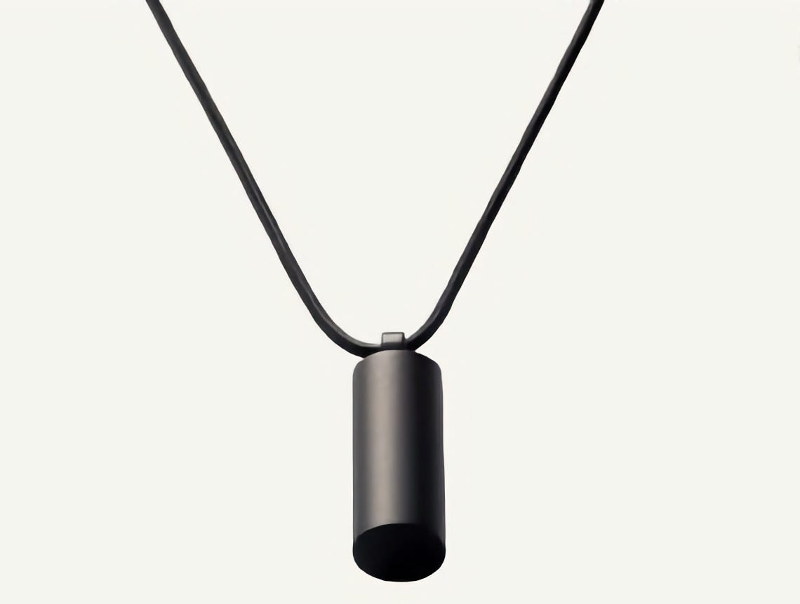 A black pendent on a black cord. Pretty boring for a begging device. But I guess that's the plan.