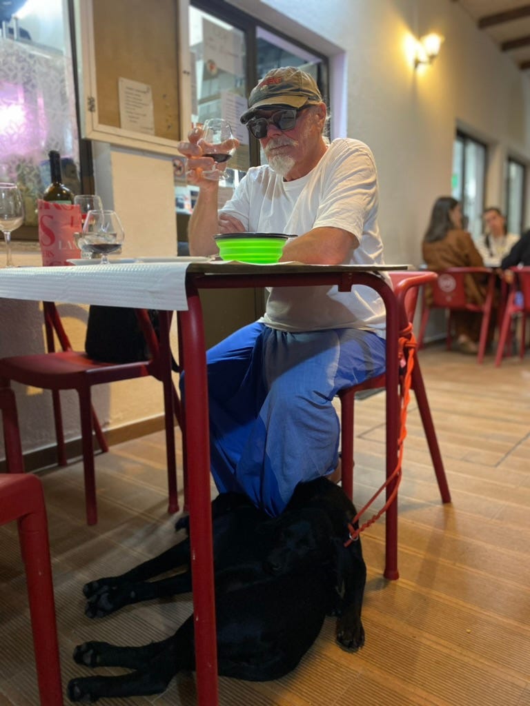 A man with cap wearing a lunghi drinking wine