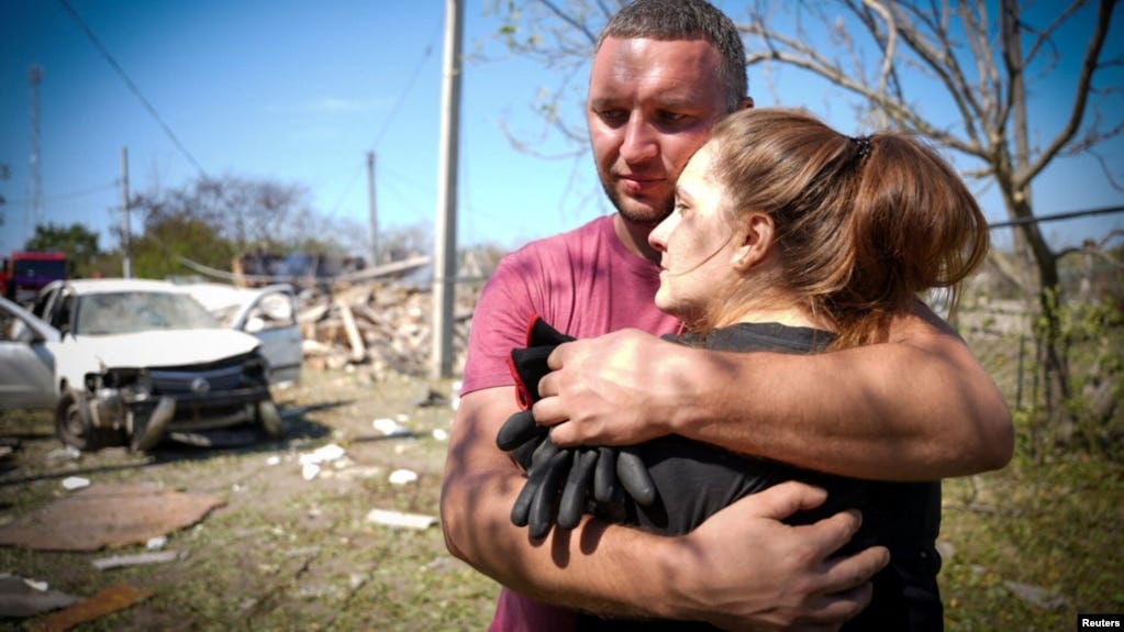 Local residents embrace each other at the site of a Russian missile strike in the Odesa region on August 26.