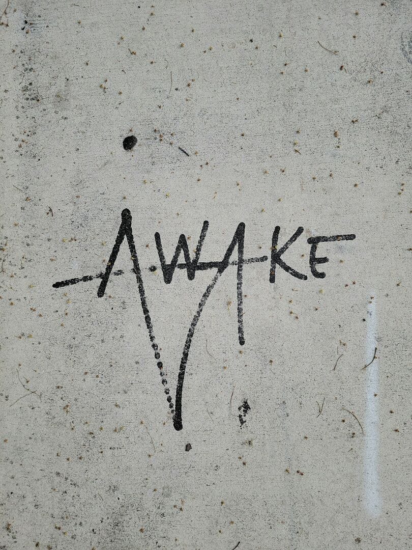 cement wall with the word awake in griffiti