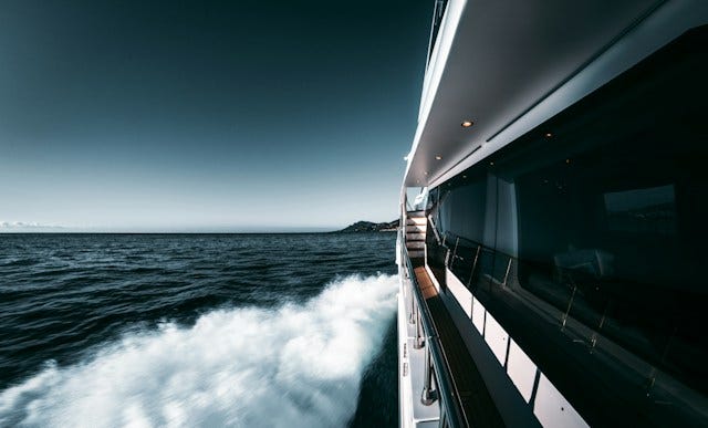 View out the window of a yacht as the wake rushes past in the water