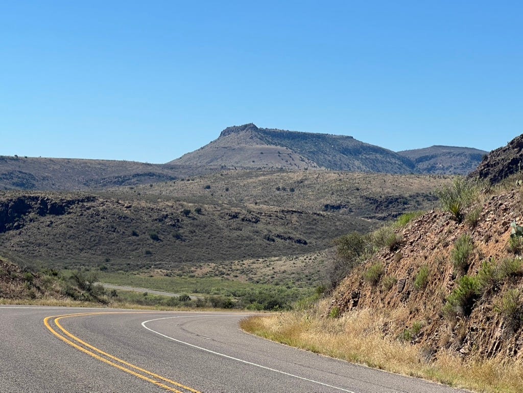 A road with mountains in the background

Description automatically generated