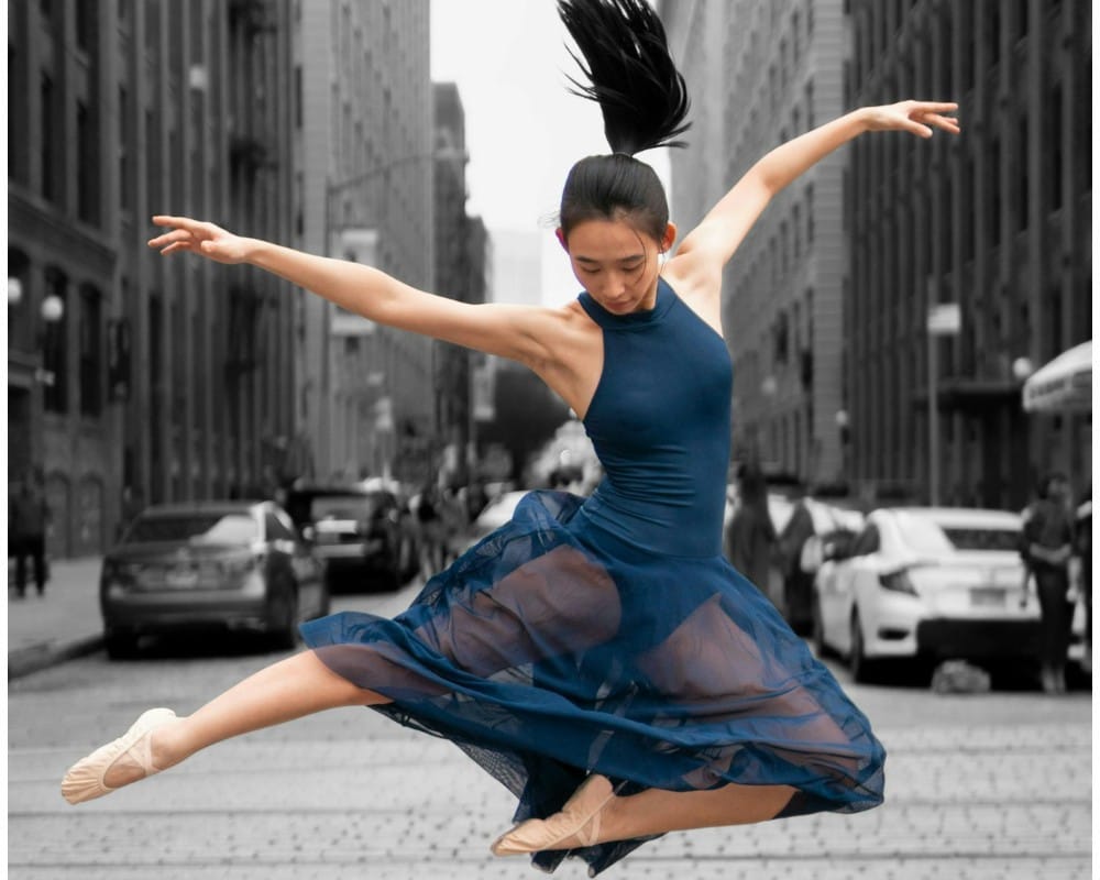 Asian ballerina dancing in a downtown setting