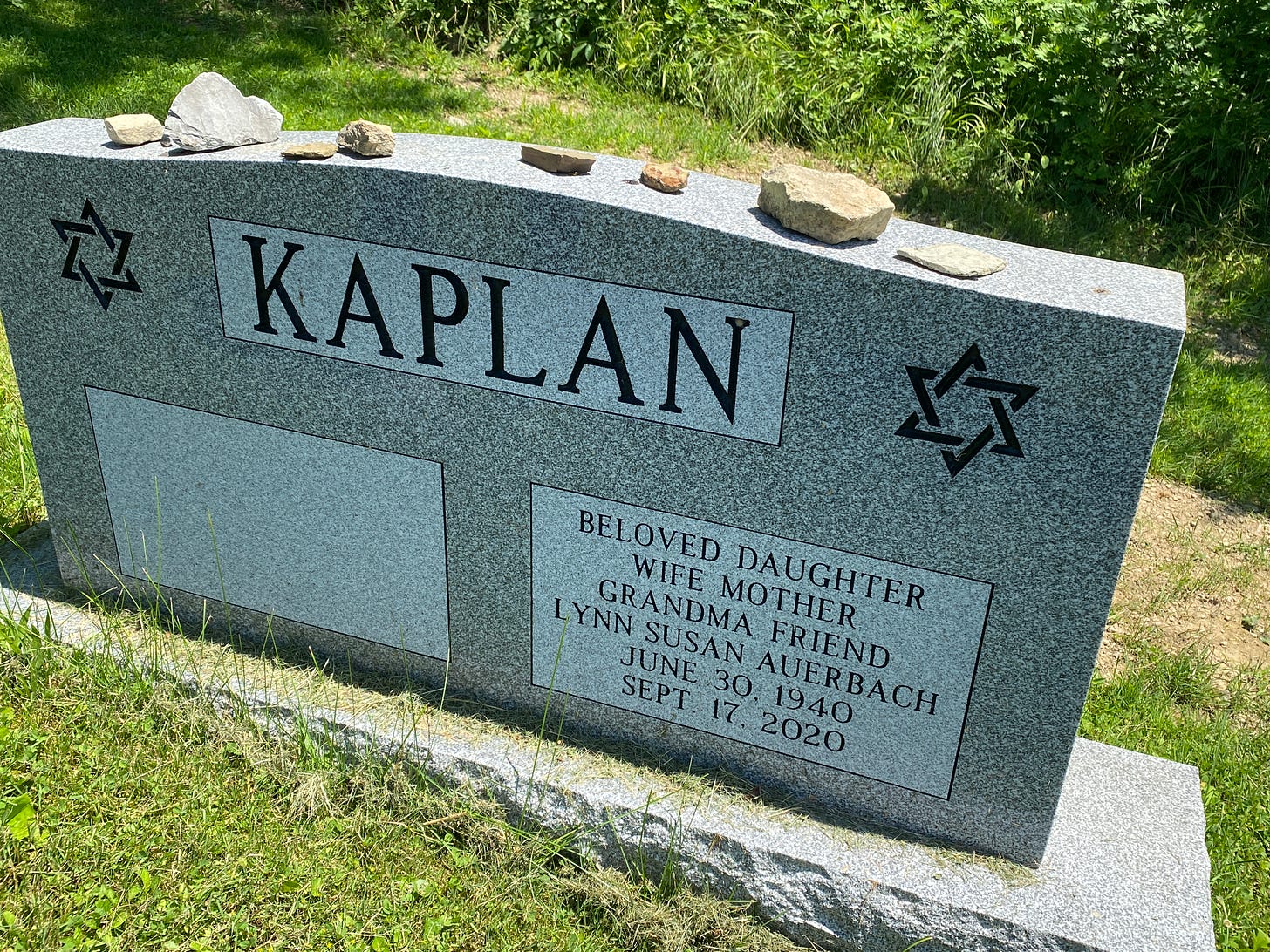 a gravestone with rocks on top of it