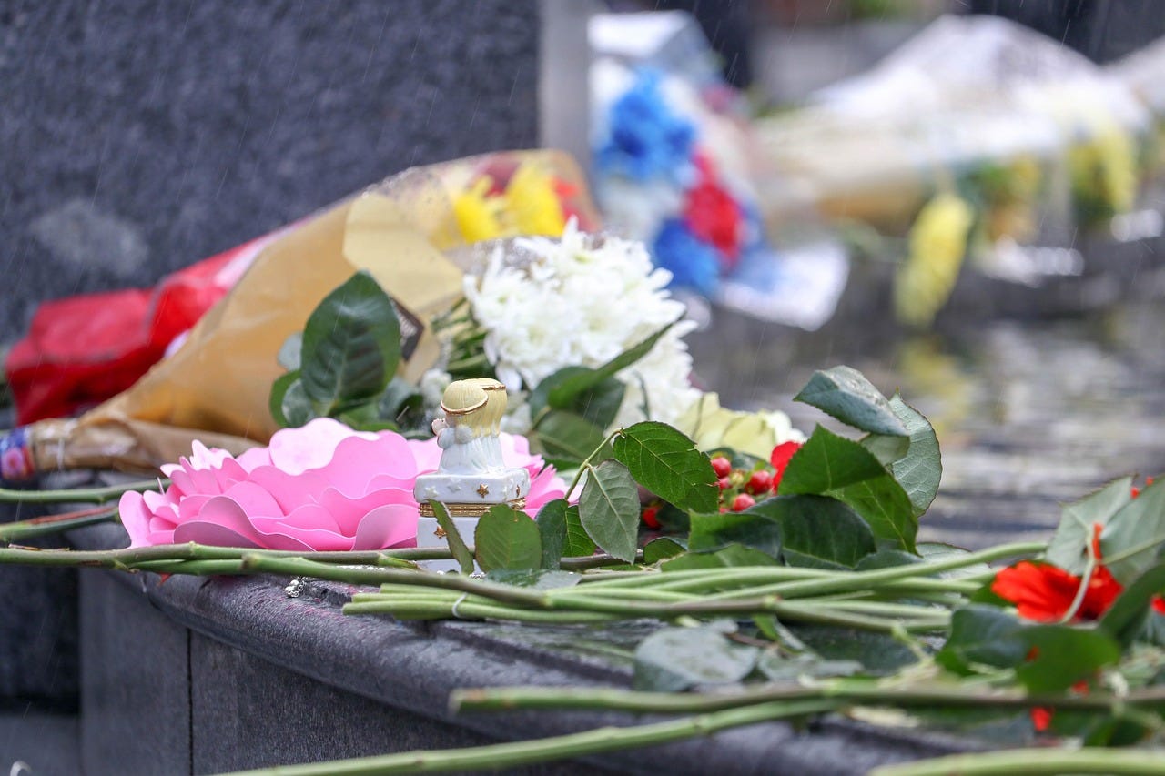 A makeshift memorial made of a few flowers and a trinket. A makeshift memorial made of a few flowers and a trinket.