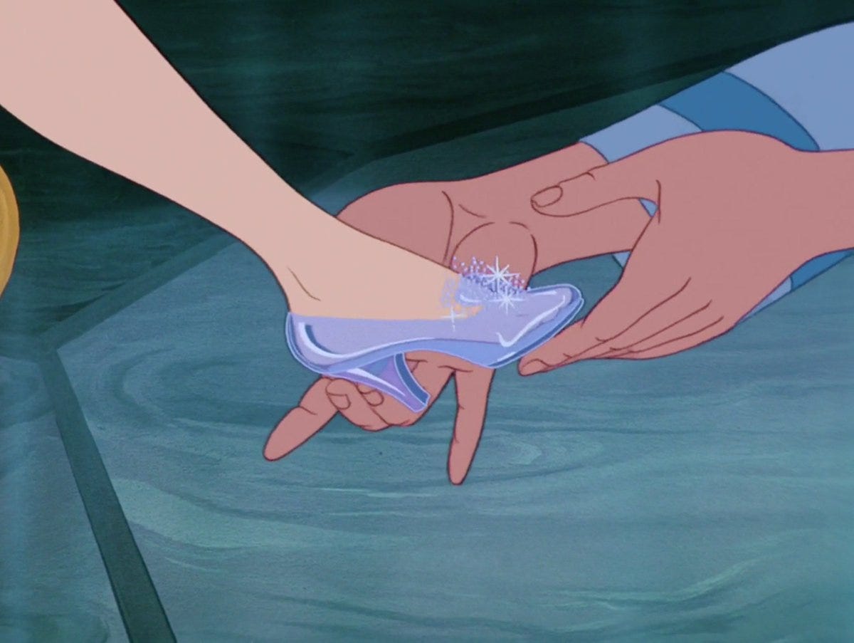 Arch duke places glass slipper on Cinderella's foot in Walt Disney's 1950 animated movie