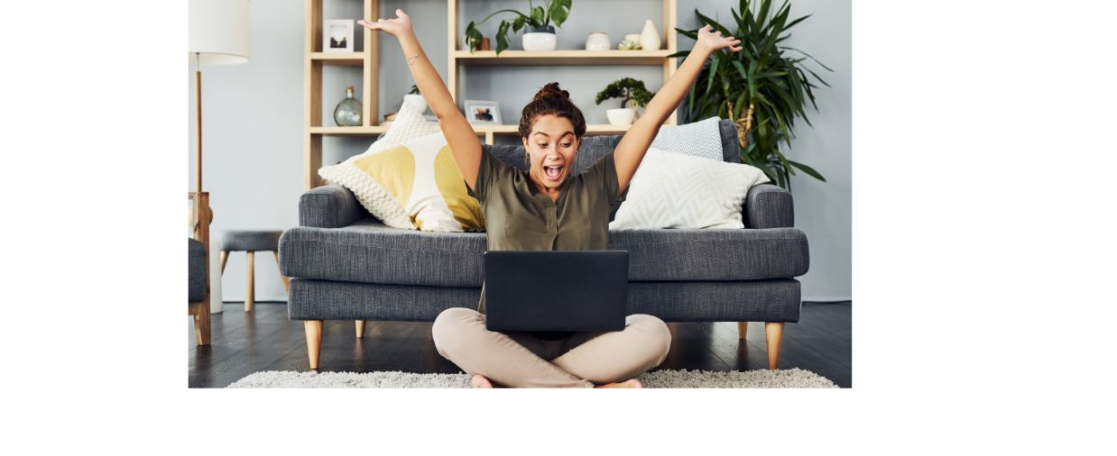 Woman celebrating looking at laptop