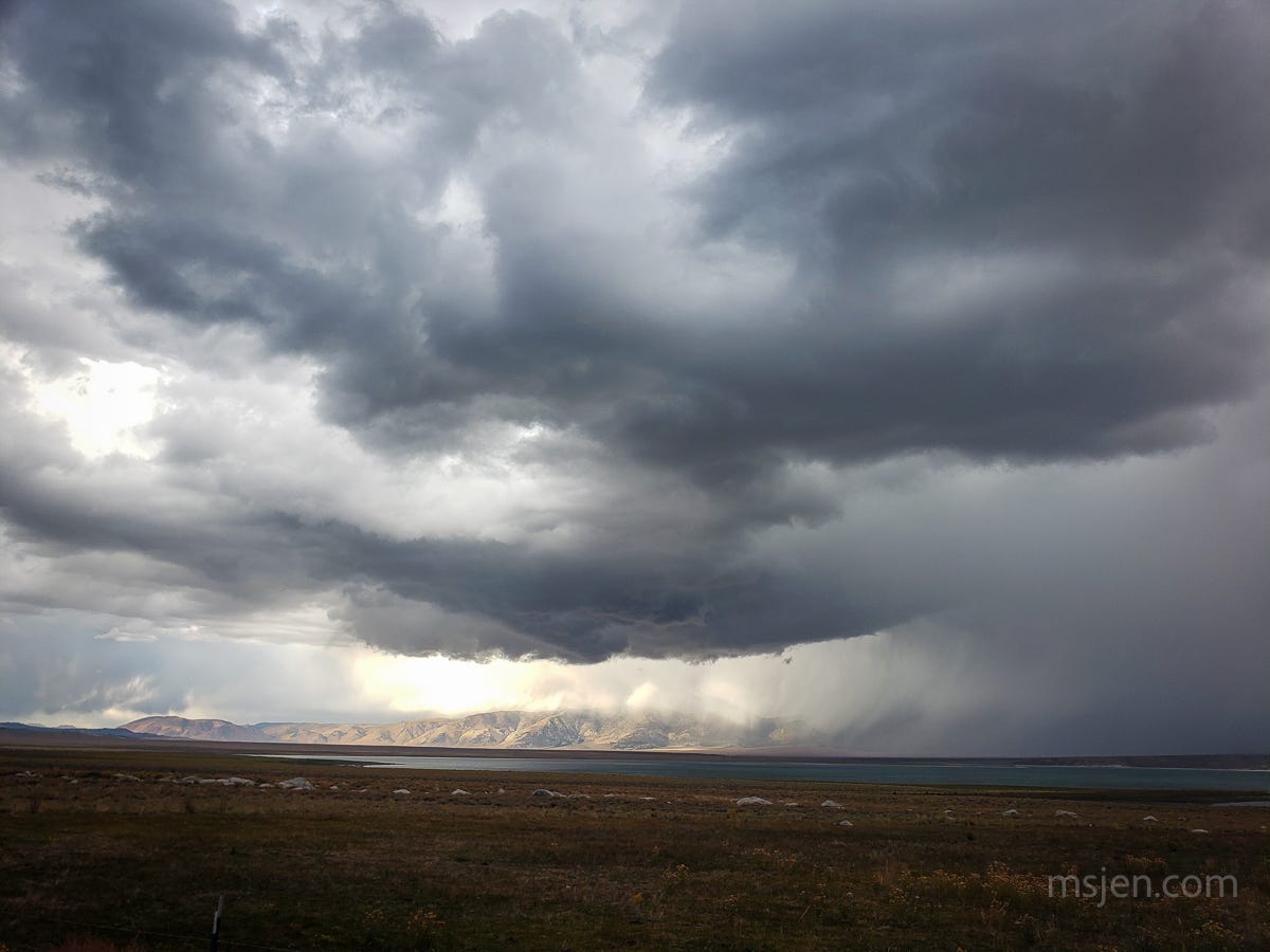 Crowley Lake and the Glass Mountains wreathed in two large and dark thunder cells with obvious snow falling on the Glass Mountains.