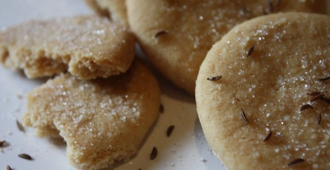 Goosnargh cakes on a plate - they look like round shortbread dusted with caraway seeds and caster sugar