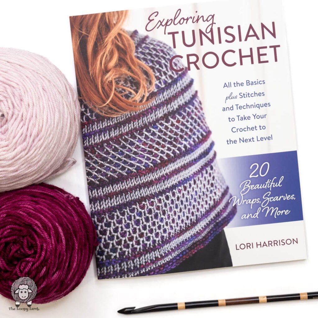 Exploring Tunisian Crochet book by Lori Harrison on a white background next to 2 cakes of yarn