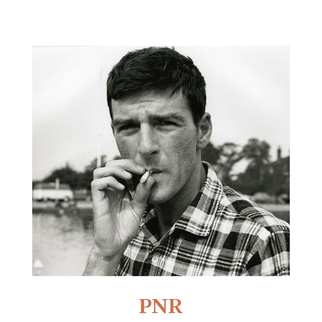 a black and white portrait of thom gunn in a checkered shirt smoking a cigarette