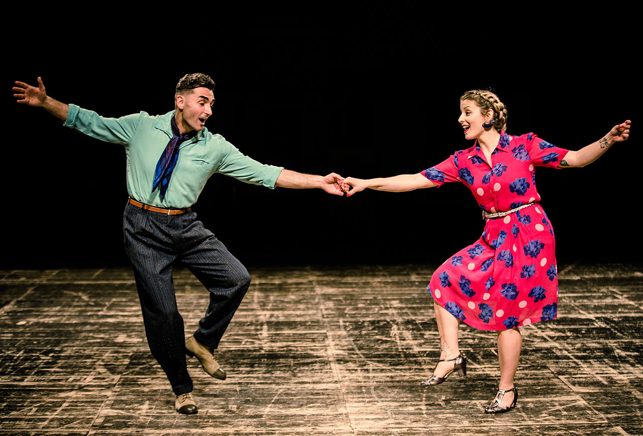Young couple swing dancing on stage