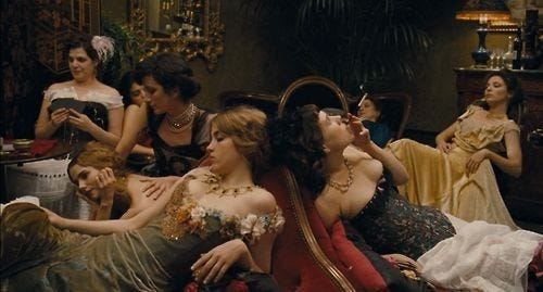 This may contain: a group of women sitting on top of a bed next to each other in dresses