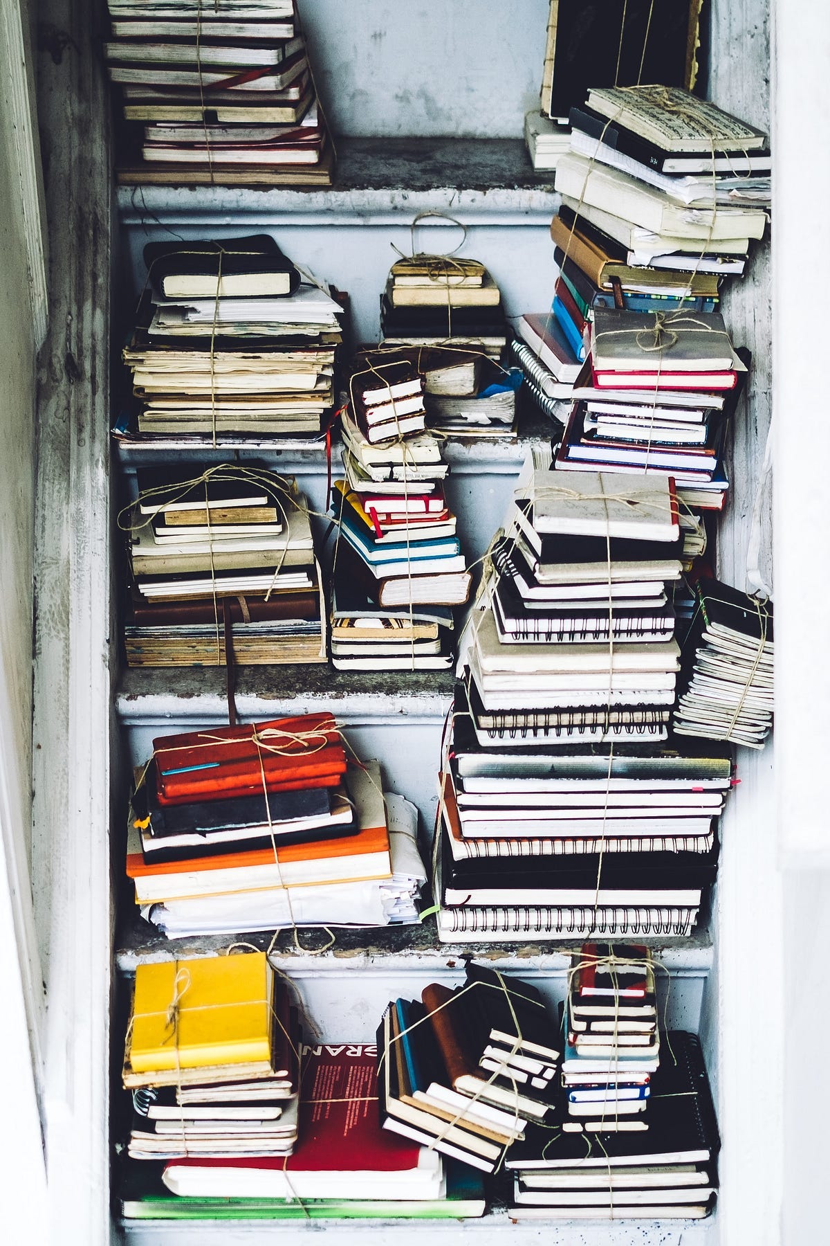 Bookshelf cluttered with untidy bundles of books