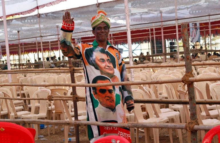 FILE - In this Thursday, March 6, 2014 file photo, a supporter of Indias Congress party wearing an outfit with portraits of former Indian Prime Ministers Indira Gandhi, top, and Rajiv Gandhi, waves to camera at an election campaign rally addressed by the party vice president and scion of the Nehru-Gandhi family Rahul Gandhi in Thane, on the outskirts of Mumbai, India. In an election campaign led by Rahul Gandhi - the son, grandson, and great-grandson of Indian prime ministers - the Indian National Congress party suffered the most crushing defeat in its 128-year history Friday when the results of India's general election were released. (AP Photo/Rajanish Kakade, File)
