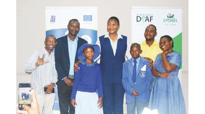 Deputy Minister of Sports, Recreation, Arts and Culture Emily Jesaya (centre) poses with some delegates and Emerald Hill School for the Deaf and Children's Home pupils during the launch of Translated Folklores into Sign Language in Harare.