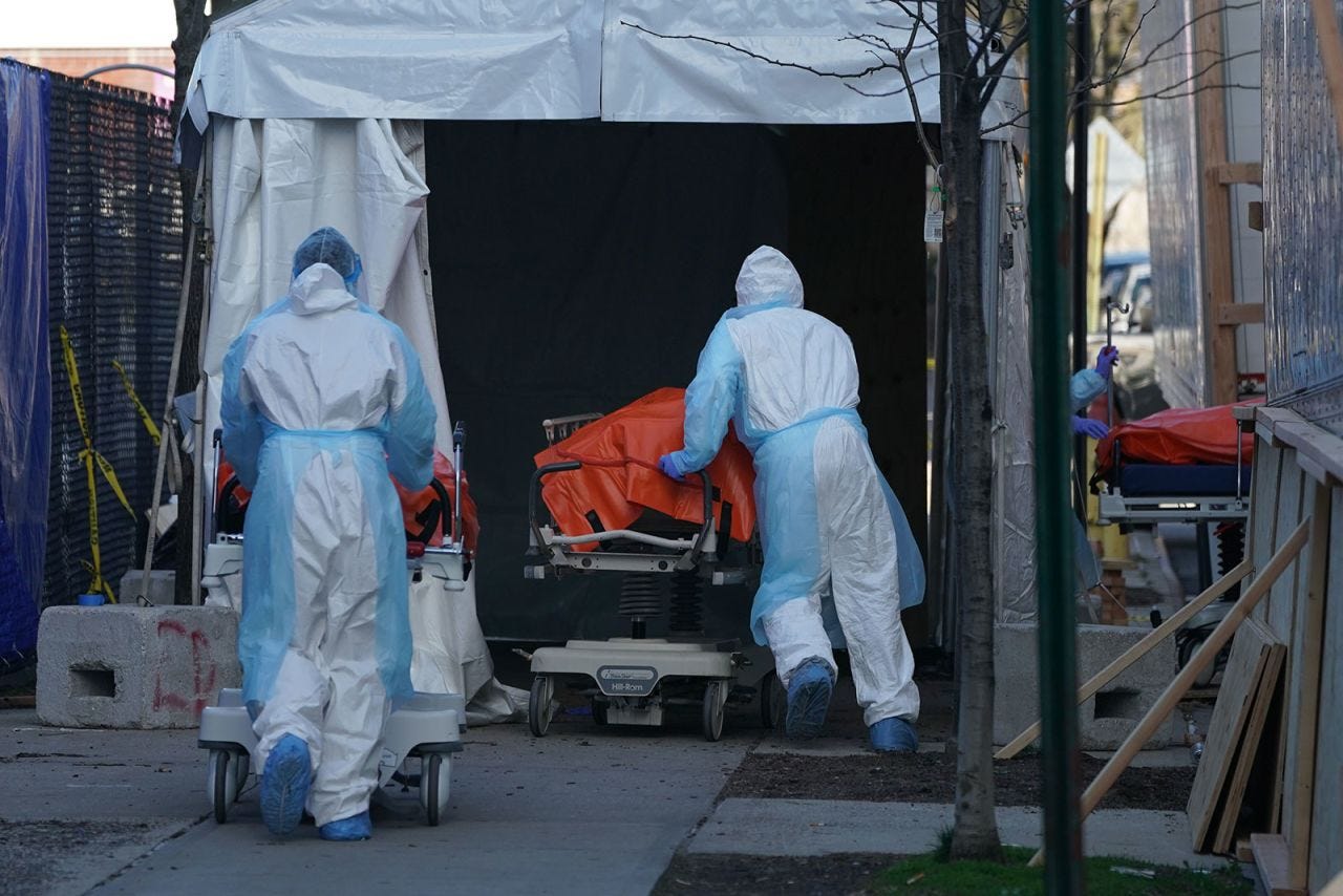 Bodies are moved to a refrigerated truck serving as a temporary morgue outside of Wyckoff Hospital in Brooklyn, New York, on April 4.