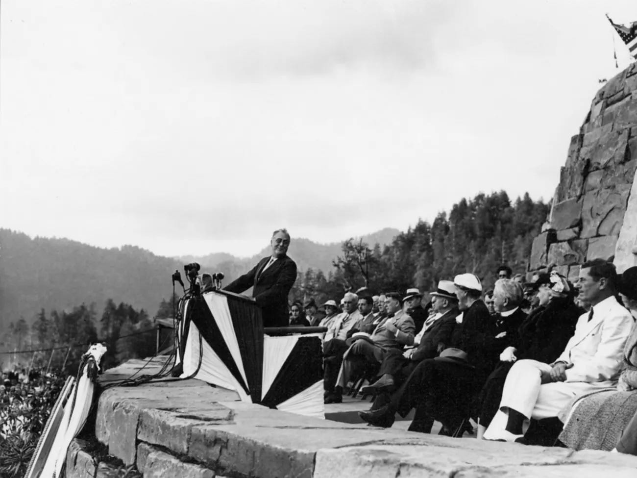 president roosevelt standing at a lectern in front of crowd