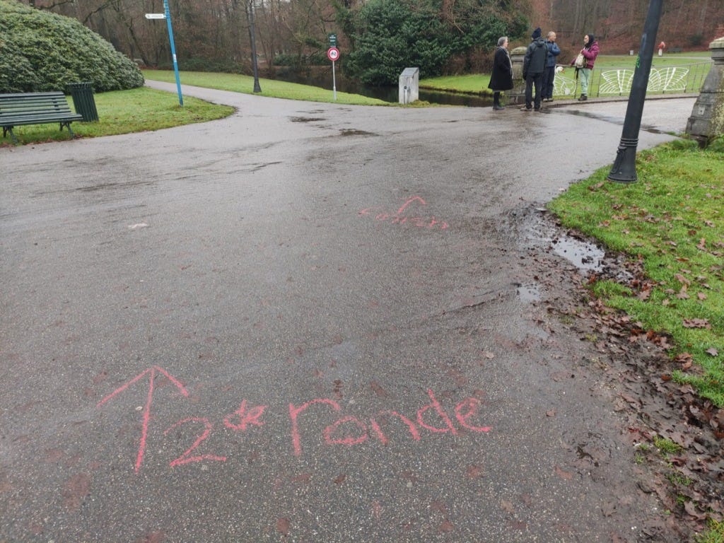 Chalk on the floor tells you to go straight on for the 2nd lap (2de ronde) and right over the bridge for the finish.