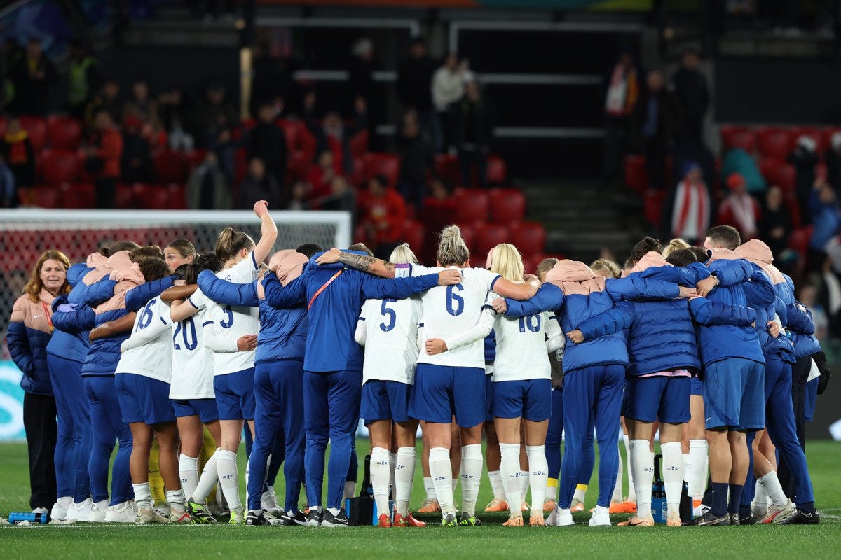 England's players and staff huddle after the game