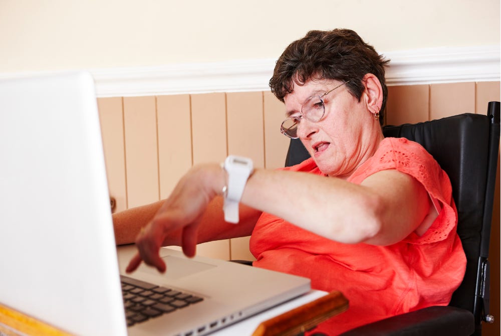 Middle aged woman with disability working at laptop