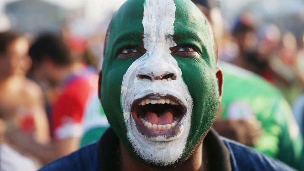 A man with a Nigerian flag painted on his face