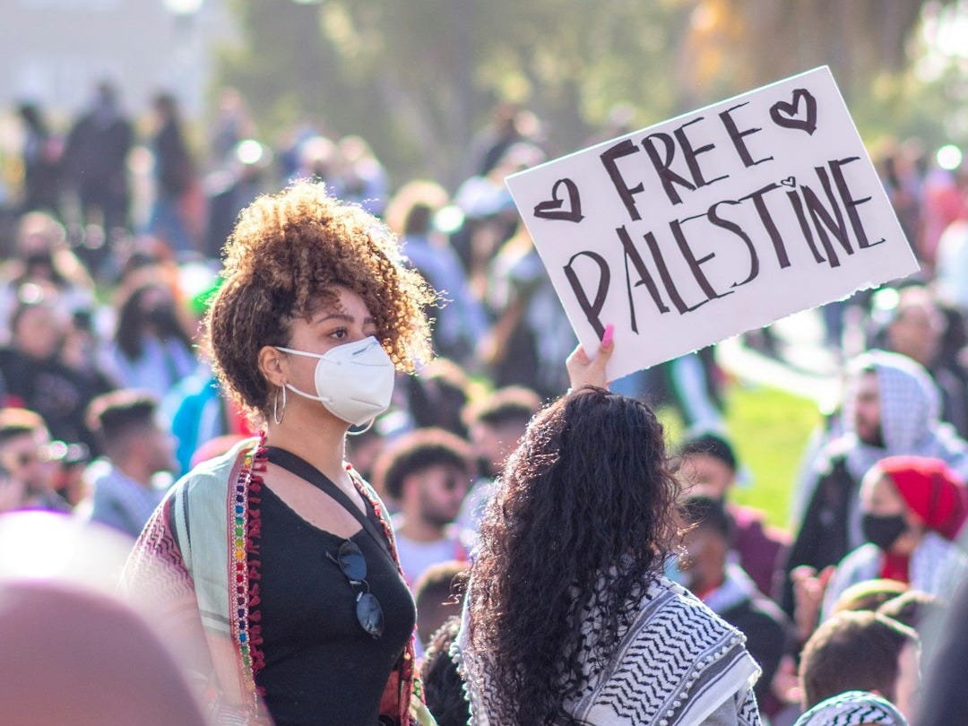 woman in black and white long sleeve shirt holding white and blue signage