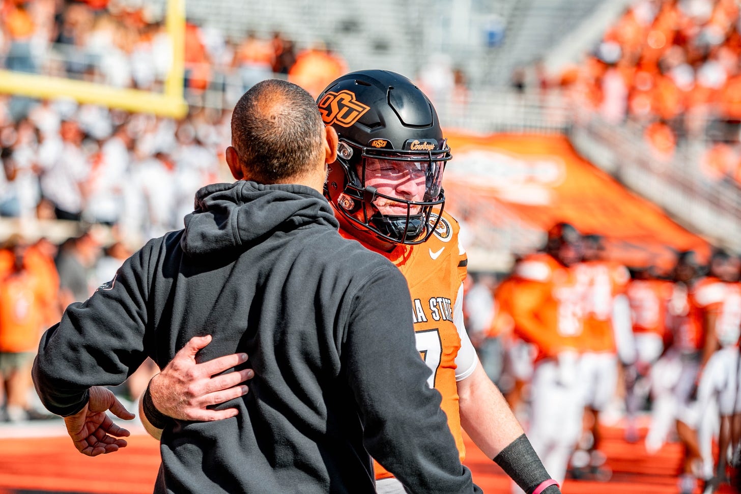 Photo of OSU quarterback Alan Bowman greeting Cowboy offensive coordinator Kasey Dunn