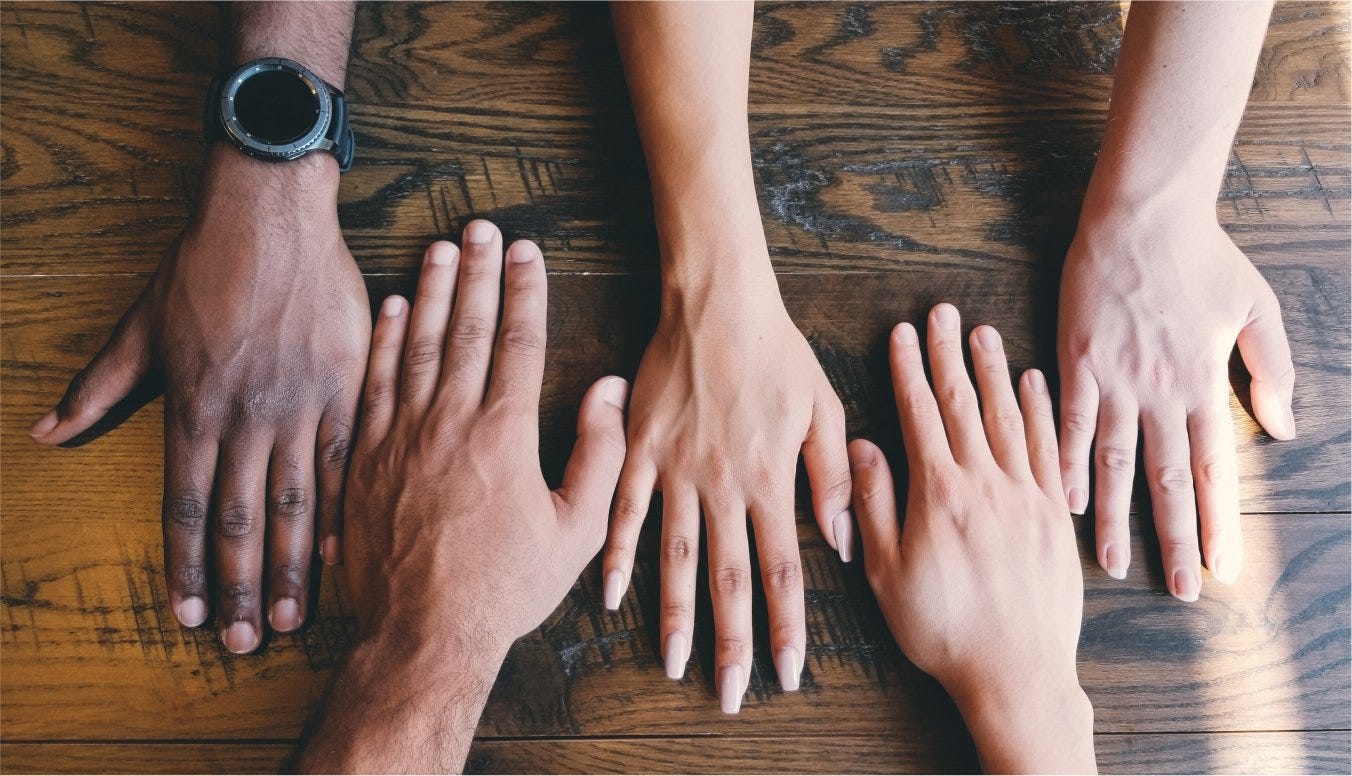 Hands laid flat on a wooden table