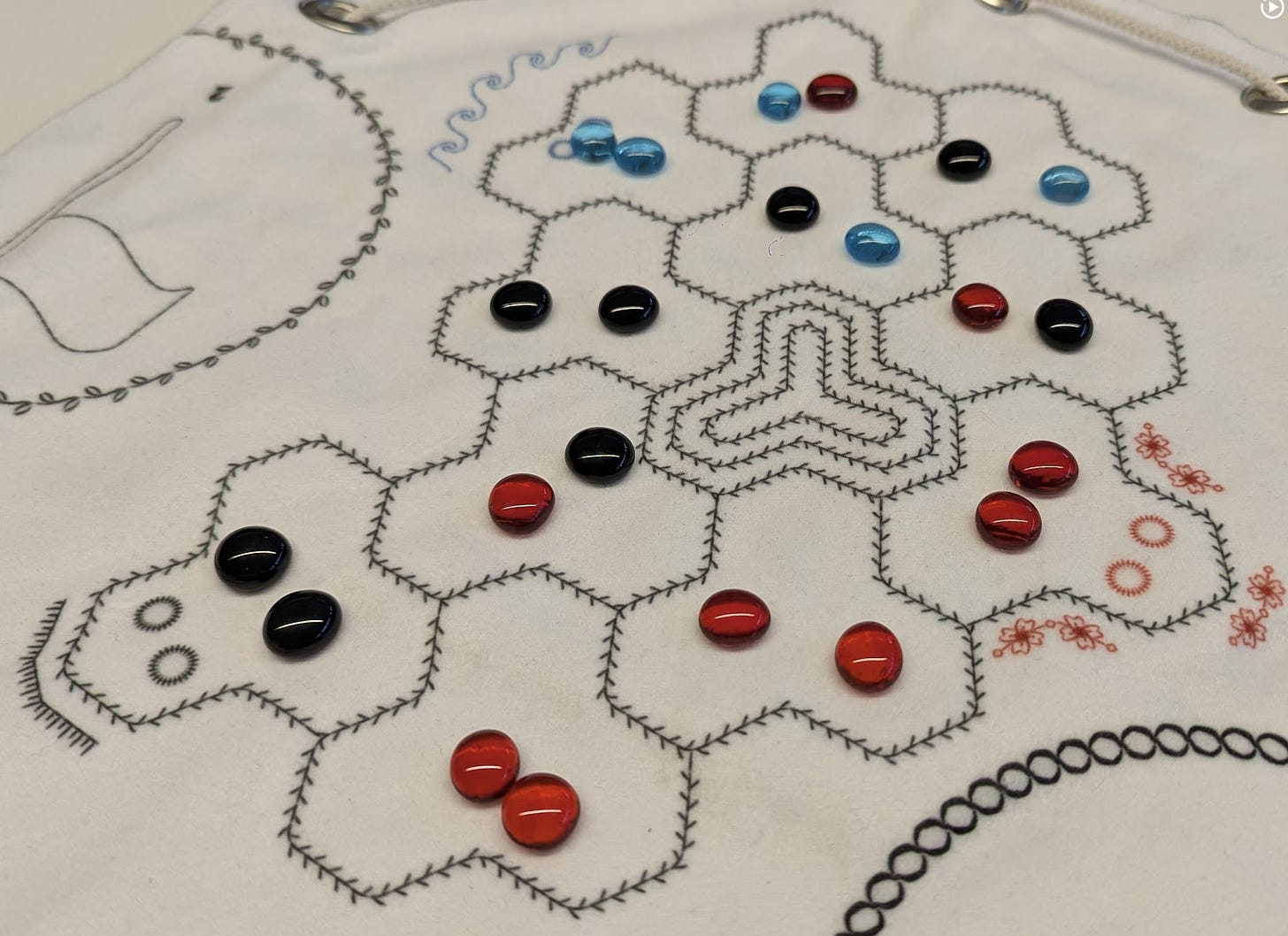 Cloth map of the game Turncoats, with black, red, and light blue glass stones placed on top