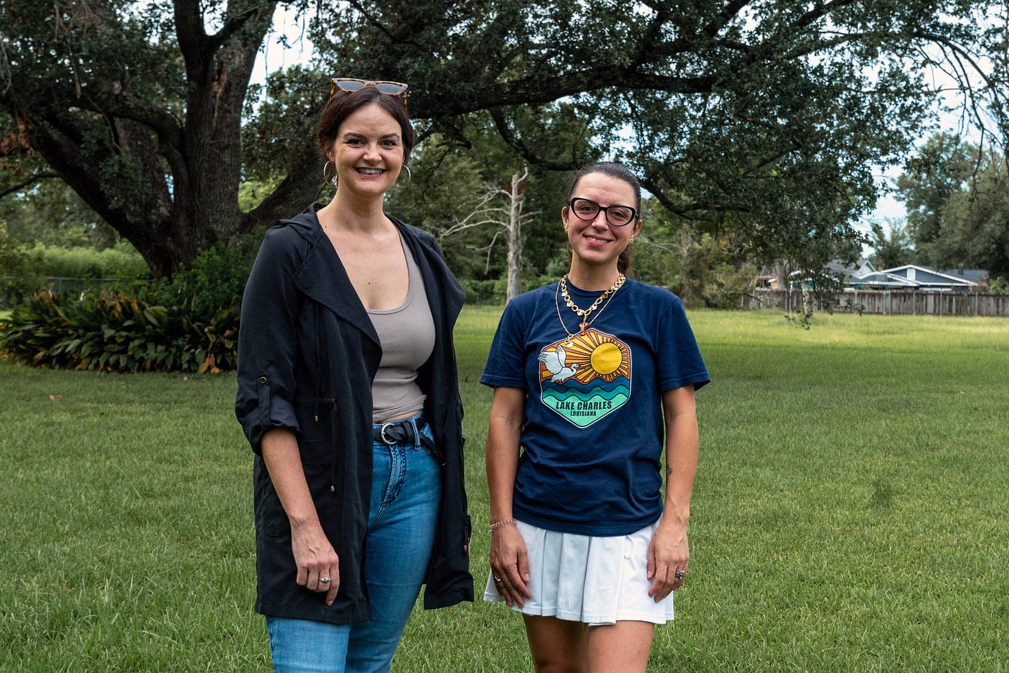 Neighbors Amie Johnson-Herbert, left, and Dominique Darbonne stand in front of the century-old oak tree they are fighting to save from development in Lake Charles.