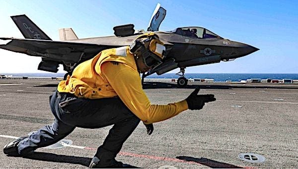 Navy Petty Officer 2nd Class Alston Adams signals to an F-35B Lightning II as it takes off from the flight deck of the USS Makin Island in the Indian Ocean, Jan. 12, 2021. (U.S. Navy photo by Petty Officer 2nd Class Kristopher S. Haley)