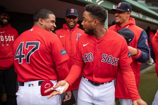 Enmanuel Valdez of the Boston Red Sox and Pablo Reyes of the Boston Red Sox compare heights in the dugout before a game against the Tampa Bay Rays on...