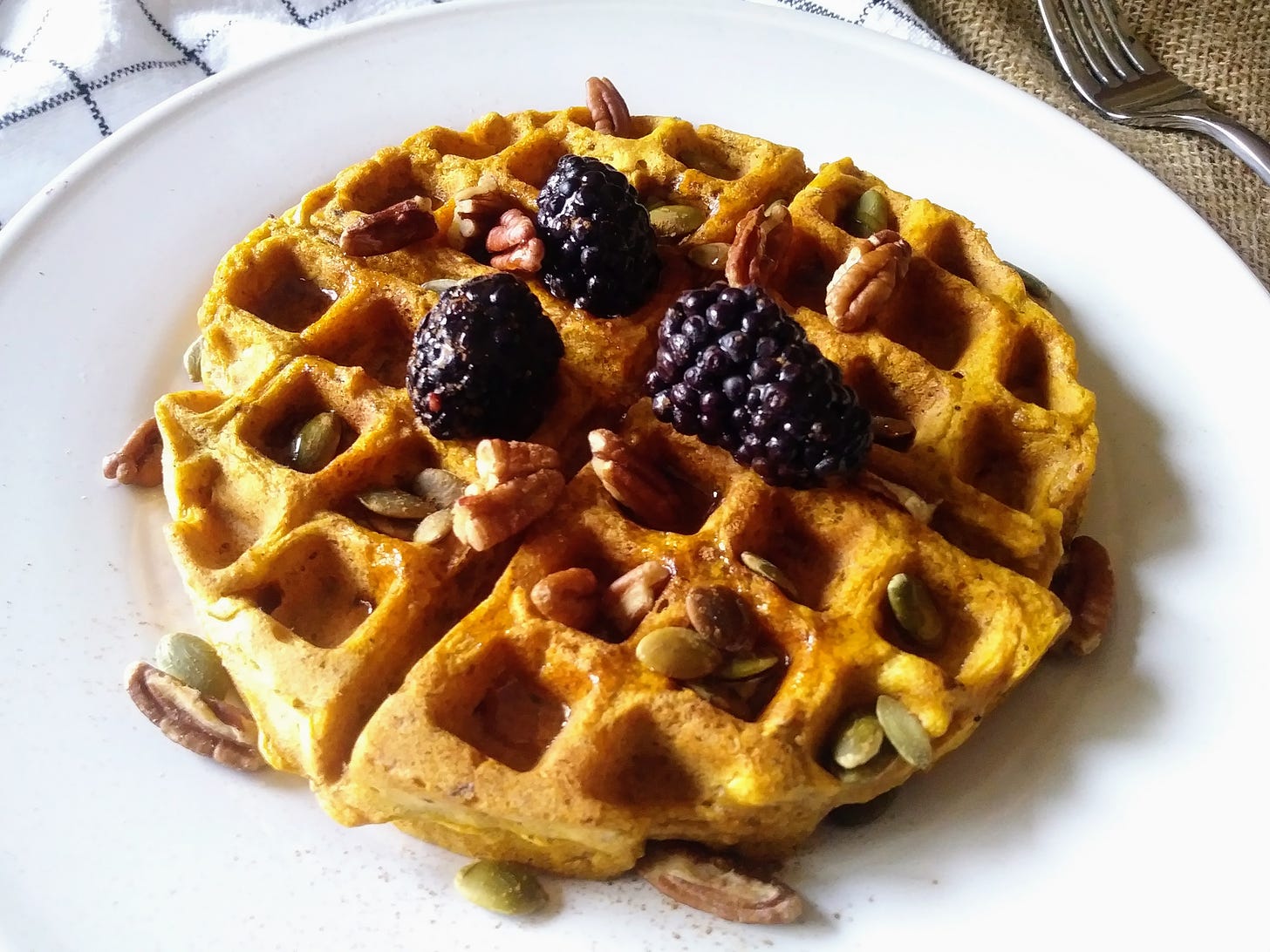 pumpkin quinoa waffle topped with pecans and blackberries