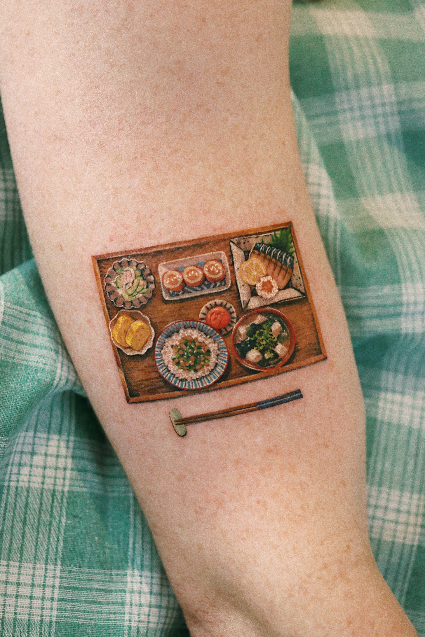 A tattoo of with beautifully painted food on an arm 