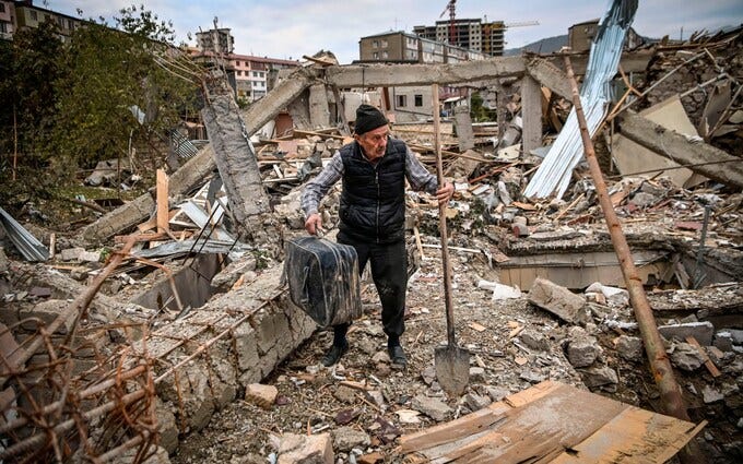 A man searches for belongings in the remains of his house, was destroyed by shelling during the Nagorno-Karabakh conflict in October 2020