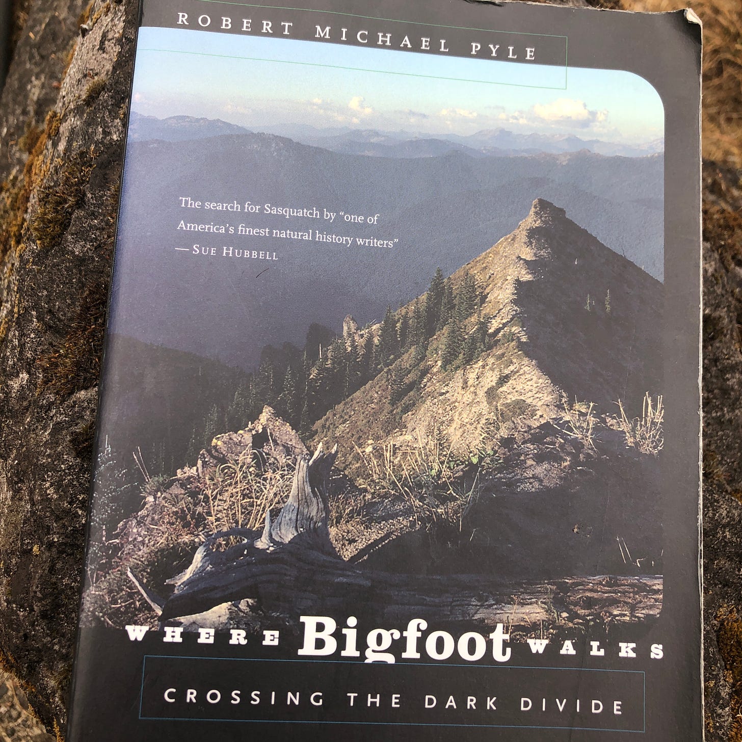 Paperback copy of “Where Bigfoot Walks,” by Robert Michael Pyle, on a rock.