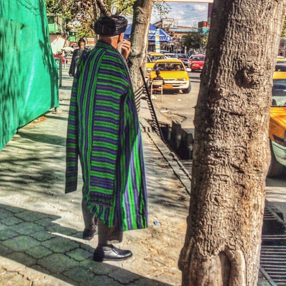 Picture of an Afghan man in Kabul wearing a traditional chapan coat